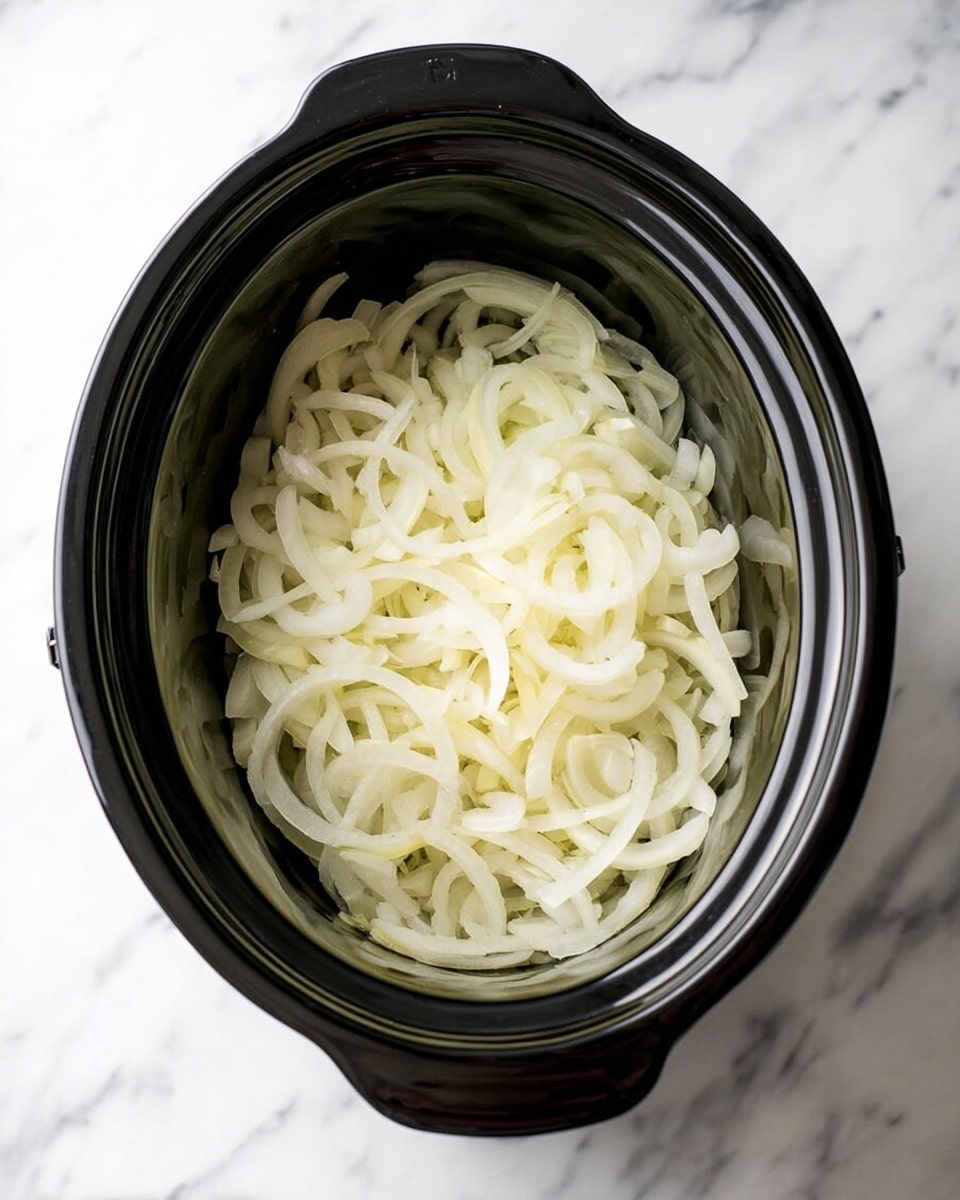A black slow cooker is filled with one layer of thinly sliced white onions, arranged loosely to cover the bottom surface evenly. The slow cooker is placed on a white marbled background, creating a clean and simple setting. The onions' pale white-yellow color contrasts with the black cooker, showing their fresh and raw texture. photo taken with an iphone --ar 4:5 --v 7
